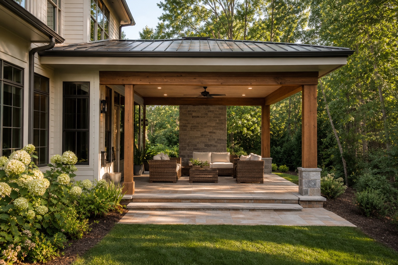 Covered cedar pavilion patio with pavers, lounge seating, ceiling fan, and hydrangeas in Cary